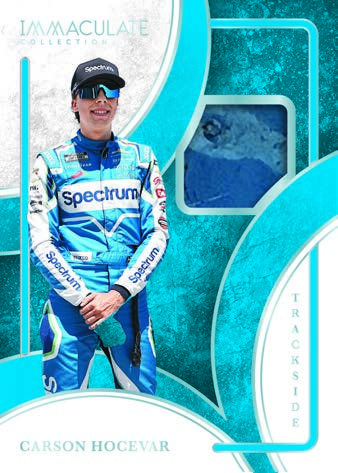 Carson Hocevar in a blue-and-white firesuit beside a memorabilia window in a blue Trackside design.