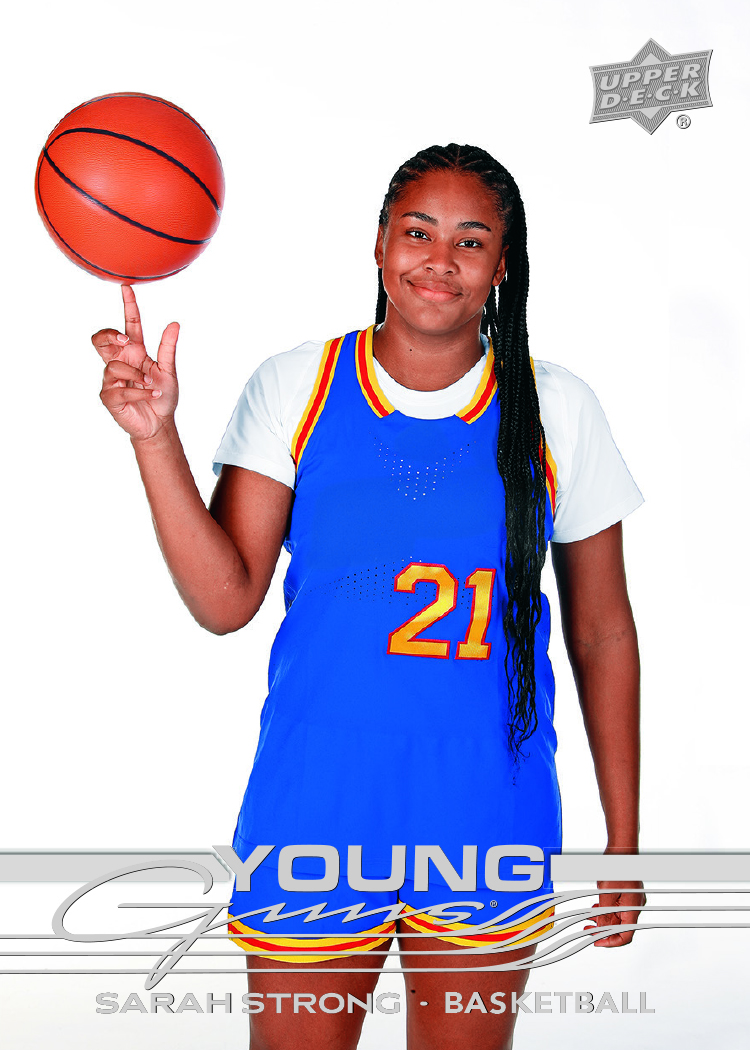 Sarah Strong spins a basketball in the white-background Young Guns design, wearing a blue No. 21 uniform.