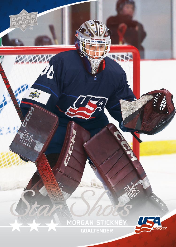 Morgan Stickney in front of a red goal on her 2026 Team USA Juniors Star Shots card, wearing a silver mask and burgundy goalie pads.