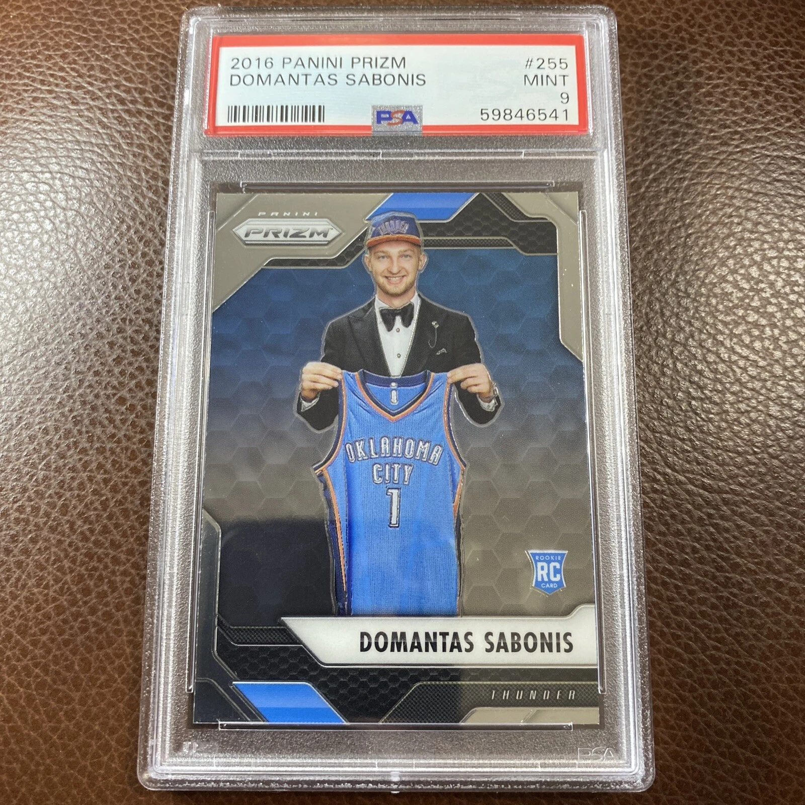 Domantas Sabonis 2016–17 Panini Prizm #255 base rookie in a PSA 9 holder, pictured in a suit holding an Oklahoma City jersey at the draft.
